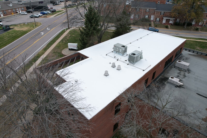 Aerial view completed white TPO flat roof replacement on brick commercial office building — Toledo Ohio