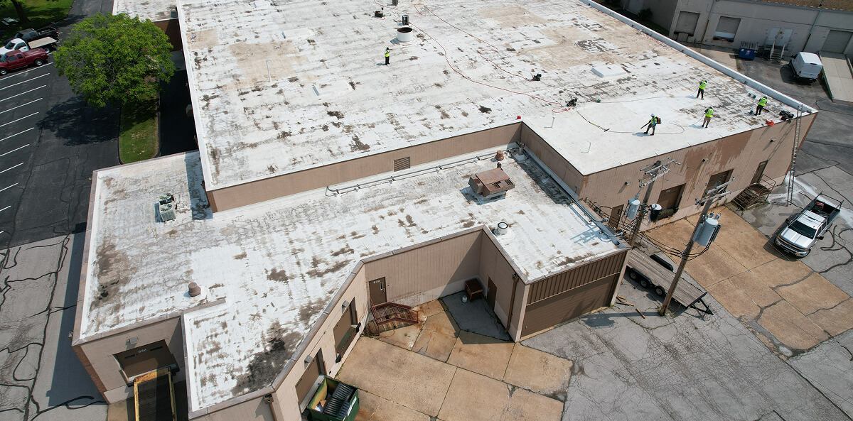 Commercial flat roof restoration crew working — before completion Toledo Ohio